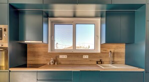 Eine moderne Küche mit Fenster, Einbaugeräten und einer Holzarbeitsplatte.