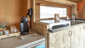 A kitchenette with a coffee maker, a small sink, and a window. - Luxury Safari Lodge Escape for 5 (Almere)