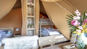 A cozy tented room with two beds, a wooden ladder, a small shelf with decorative items, and a vase with flowers. - Luxury Safari Lodge Escape for 5 (Almere)