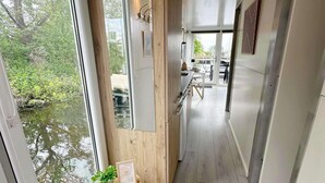 Une cuisine moderne avec vue sur une rivière, agrémentée d’éléments en bois et comprenant un coin repas avec une table et des chaises.