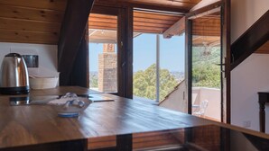 A wooden kitchen with a view of a cityscape through a sliding door. - Villa Desiderio The Belvedere (Angri)