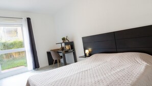 Ein Schlafzimmer mit einem Bett, einem Schreibtisch und einem Stuhl.