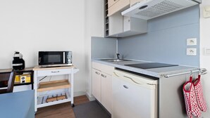 Una cocina compacta con microondas, tostadora y una pequeña encimera.