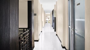 A corridor with a wooden railing, a door with a sign, and a tiled floor. - Cozy Twin Escape with Free WiFi and Parking (Padang)