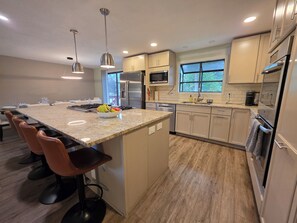 A modern kitchen with a central island, stainless steel appliances, and a large window. - Perfect 5-bedroom house with AC in wonderful Coeur d'Alene (Coeur d'Alene)