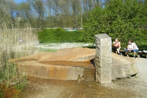 A stone structure near a body of water with a bench and greenery in the background. - Holiday apartment with 2 bedrooms (Merzig-Bietzen)