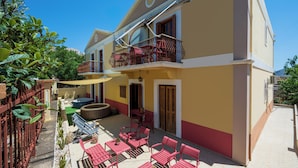 Ein zweistöckiges Gebäude mit Balkon, Außenbereich und Whirlpool.