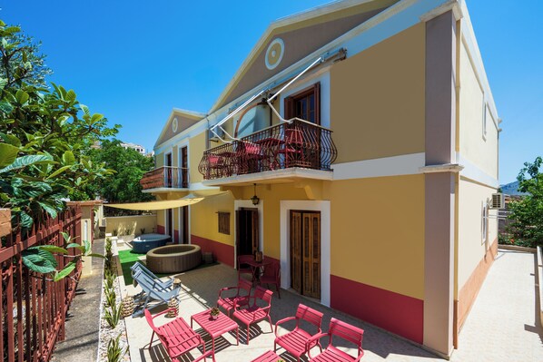 A two-story building with a balcony, outdoor seating, and a hot tub. - Pinotsi Room 5 -2 single (Simi)