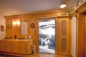 A wooden interior with a large mirror, a decorative cabinet, and a door leading to a scenic view. - Holiday apartment with 1 bedroom (Wallgau)