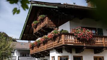 Ein traditionelles Chalet mit Holzbalkonen, weißen Wänden und Blumenkästen.