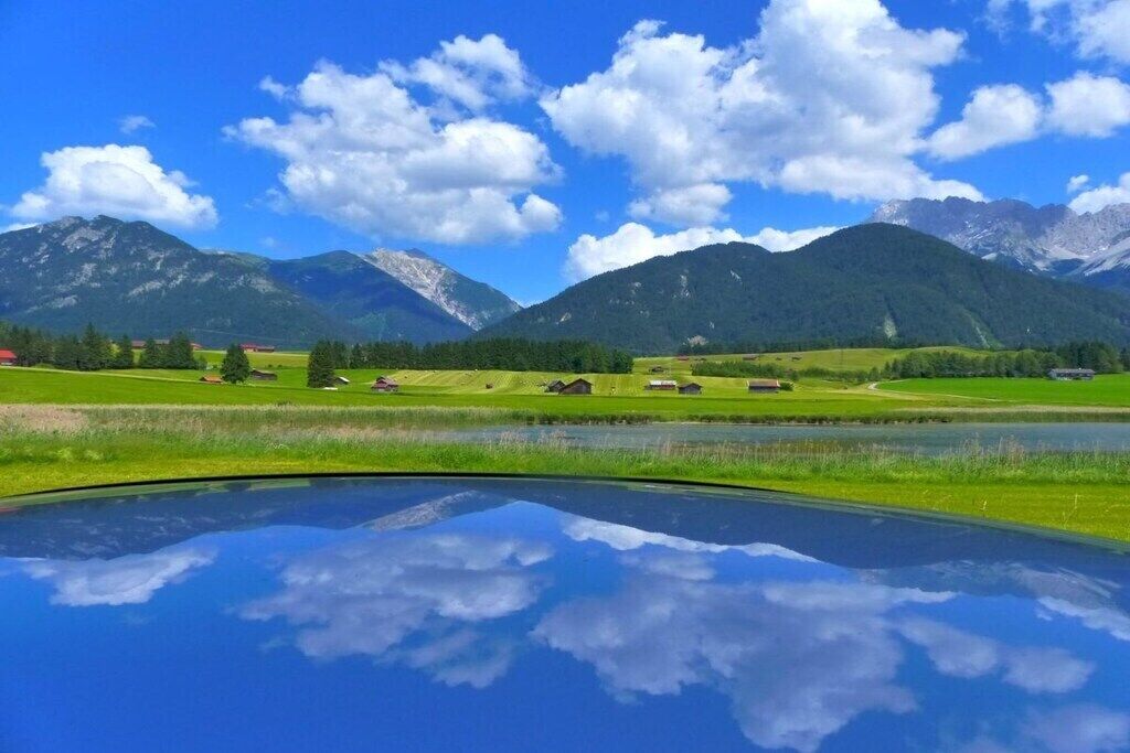 Eine Berglandschaft mit blauem Himmel und einem Gewässer im Vordergrund.