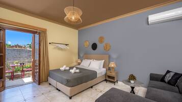 Un dormitorio con cama, mesitas de noche, un sofá, un balcón y vistas al exterior.