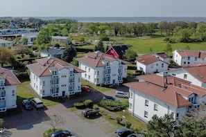 Ein Wohngebiet mit weißen Gebäuden, roten Dächern und einem Parkplatz.
