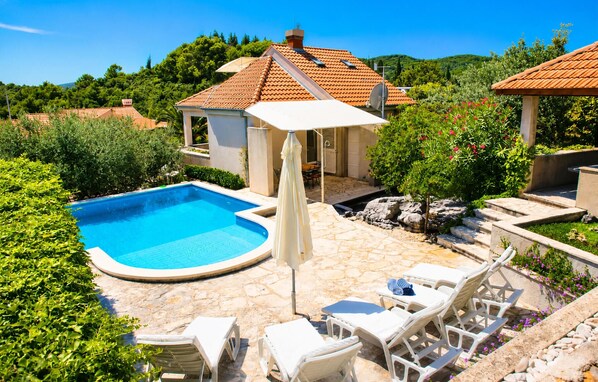 A swimming pool with lounge chairs and a covered seating area. - Beautiful home in Korcula (Korcula)