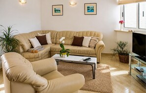 A living room with a sectional sofa, a coffee table, a TV, and two framed pictures on the wall. - Beautiful home in Korcula (Korcula)