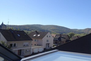 Ein Wohngebiet mit Häusern, blauem Himmel und einem Berg im Hintergrund.