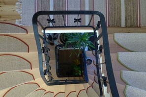 Ein Zimmer mit schwarzem Metallbettgestell, einem kleinen Topfpflanzen und einem Holzkopfteil.