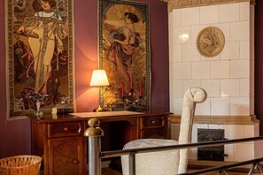 A room with a desk, a lamp, a chair, and two large tapestries on the wall. - Holiday apartment with 2 bedrooms (Zittau)