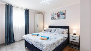 A bedroom with a bed, two bedside tables, a nightstand, a painting, and a window with curtains. - Nice apartment in Krasica with WiFi (Krasica)