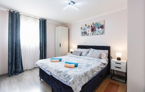 A bedroom with a bed, two bedside tables, a nightstand, a painting, and a window with curtains. - Nice apartment in Krasica with WiFi (Krasica)