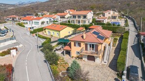 A residential area with houses, a road, and a hilly landscape in the background. - Nice apartment in Krasica with WiFi (Krasica)