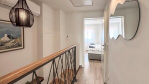 A hallway with a wooden railing, a painting, a mirror, and a bed in the background. - 2 bedroom awesome home in Jadranovo (Jadranovo)
