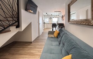 Ein modernes Interieur mit Treppe, einer Sitzecke, einem Essbereich und einer Küche.