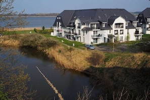 Ein großes, mehrgeschossiges Wohngebäude im modernen Architekturstil, in Wassernähe gelegen.