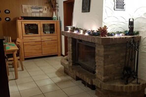 Eine Küche mit Kamin, Holzschränken und einem Essbereich.