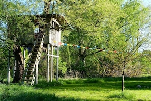 A treehouse with a wooden ladder and a rope bridge. - Holiday home in Bugewitz with swimming pool (Bugewitz)
