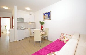 Ein gemütlicher Wohnbereich mit Küchenzeile, Essplatz und Sofa.