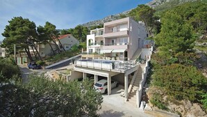 Un edificio a più piani con un balcone, una piscina e un'area di parcheggio.
