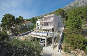 A multi-story building with a balcony, a swimming pool, and a parking area. - Awesome apartment in Brela with swimming pool (Brela)