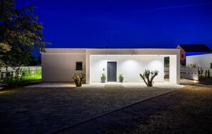 A modern building with a flat roof, a central door, and two potted plants on either side. - Beautiful home in Donji Prolozac (Donji Prolozac)