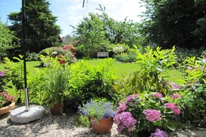 A garden with various plants and a bench. - Bender Grinding Shops (Ulsnis)