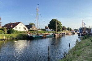 Ein Kanal mit Booten, Häusern und viel Grün.