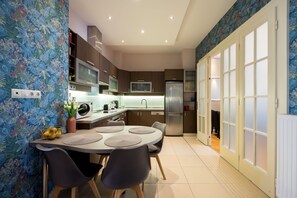 Eine moderne Küche mit Essbereich, einer Mikrowelle, einem Kühlschrank und einem Fernseher.