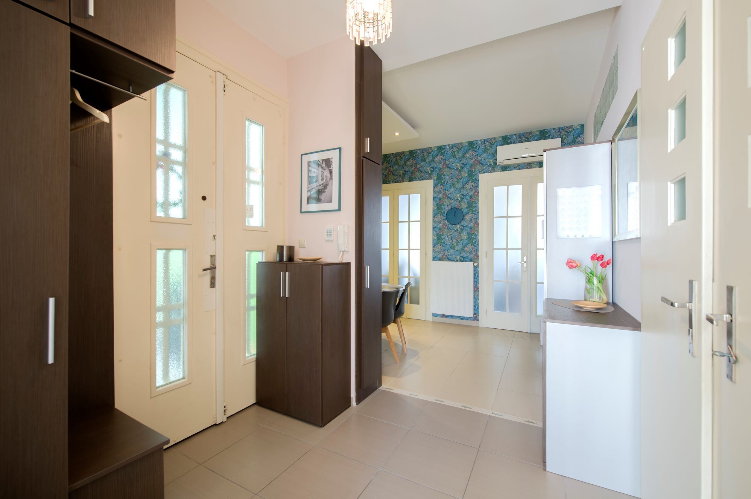 Eine moderne Küche mit weißen Schränken, einem Kühlschrank und einem Essbereich mit Tisch und Stühlen.