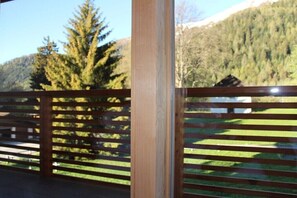 Une clôture en bois offrant une vue sur une montagne boisée.