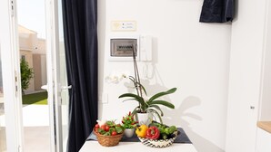 Zona de recepción con escritorio, teléfono, señal de Wi-Fi y plantas en macetas.