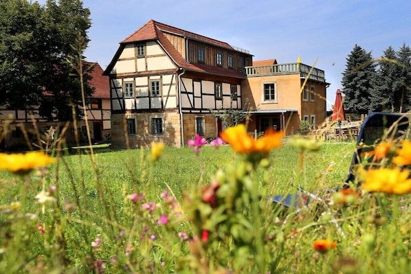 A traditional half-timbered house with a garden in front. - Holiday home Lindenhof (Pirna)