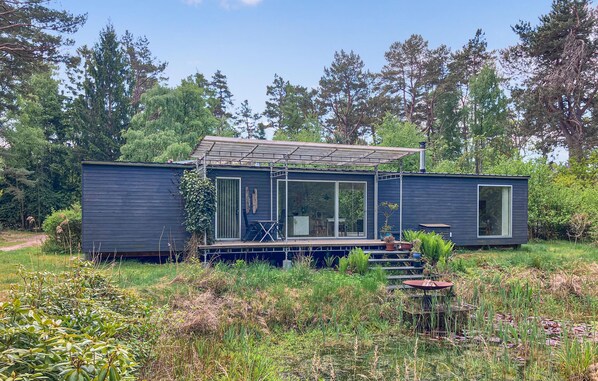 Ein modernes Haus mit Terrasse, großen Fenstern und Garten.