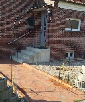 Ein Backsteinhaus mit einer Metalltreppe, die zu einer Tür mit der Aufschrift '22' führt.