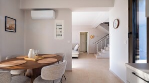 A dining area with a wooden table, chairs, and a buffet tray. There is a staircase leading to another room. - Alekos Beach Houses-Meliti Villa (Kefalonia)