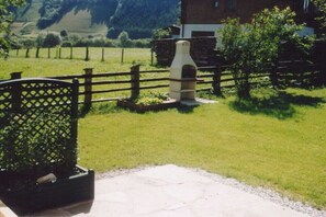 A stone oven, a wooden fence, and a building in a rural setting. - Holiday apartment with 2 bedrooms (Rauris)