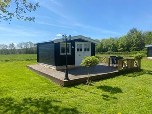 A small, single-story building with a deck, a door, and windows. - 4 Star Holiday Home in Ansager (Ansager)