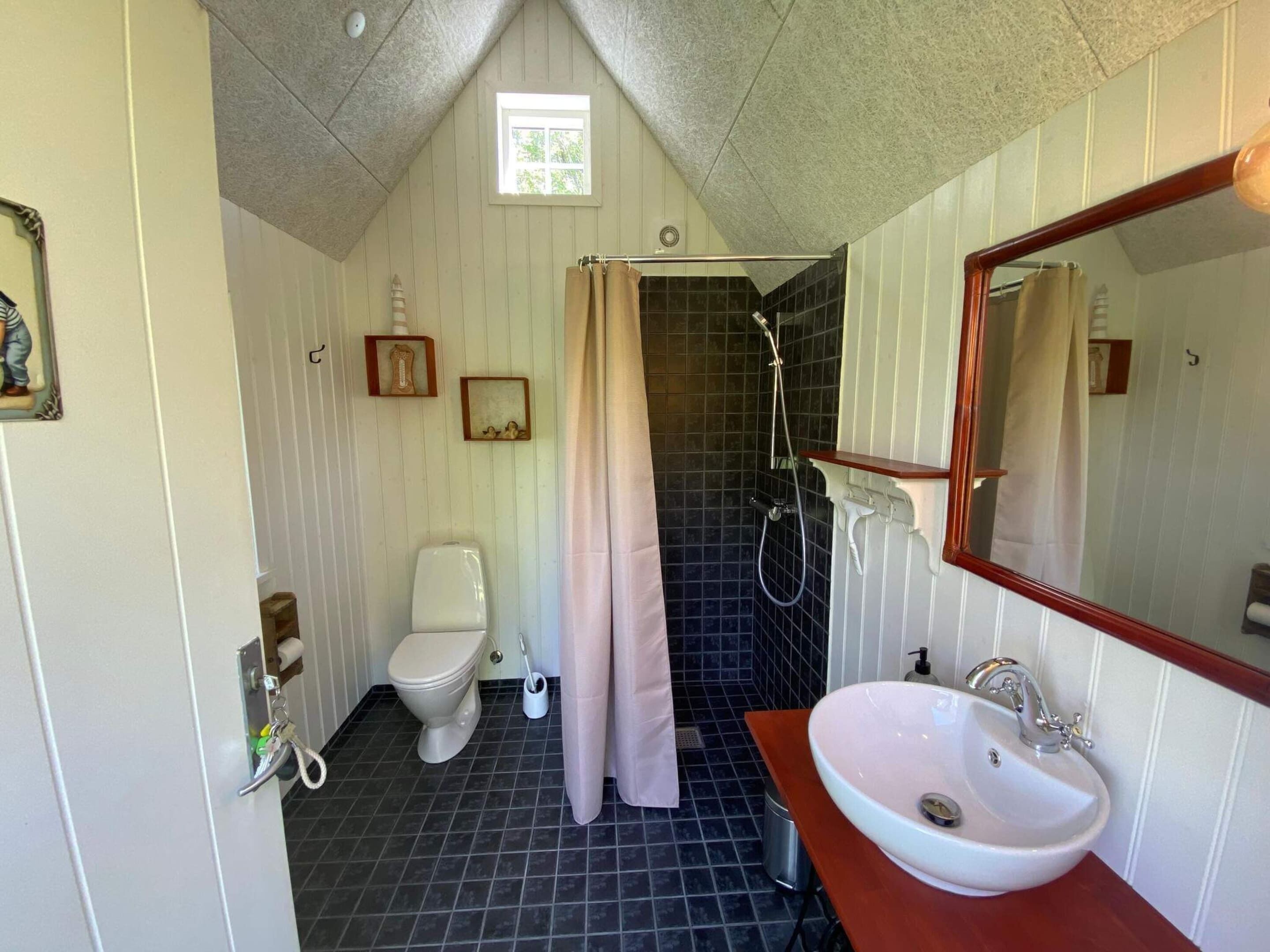 Ein Badezimmer mit Toilette, Dusche, Waschbecken und Spiegel.
