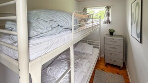 A bunk bed room with a small dresser and a window with curtains. - Nice home in Sydals with WiFi (Sydals)