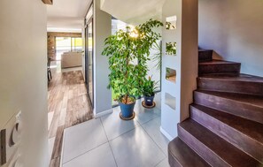 A modern interior with a staircase, potted plants, and a view into a living area. - Cozy home in Bassens with WiFi (Bassens)