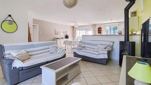A living room with two sofas, a coffee table, a dining area with chairs, a kitchen area, and a fireplace. - Awesome home in Soubise (Soubise)